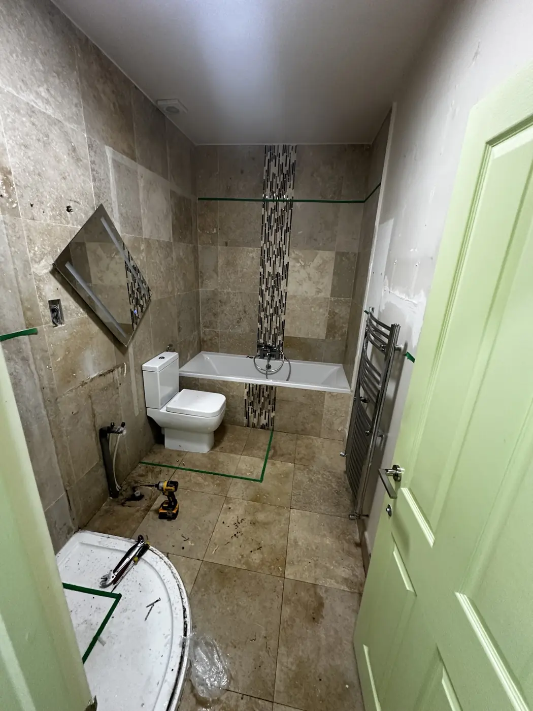 Existing beige tiled bathroom as strip-out work begins