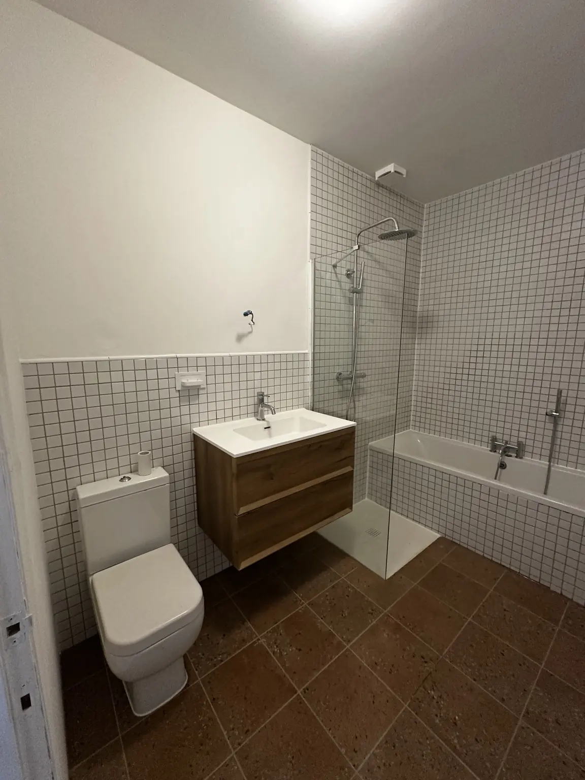 Finished bathroom with white mosaic tiling, bath, walk-in shower, vanity and toilet